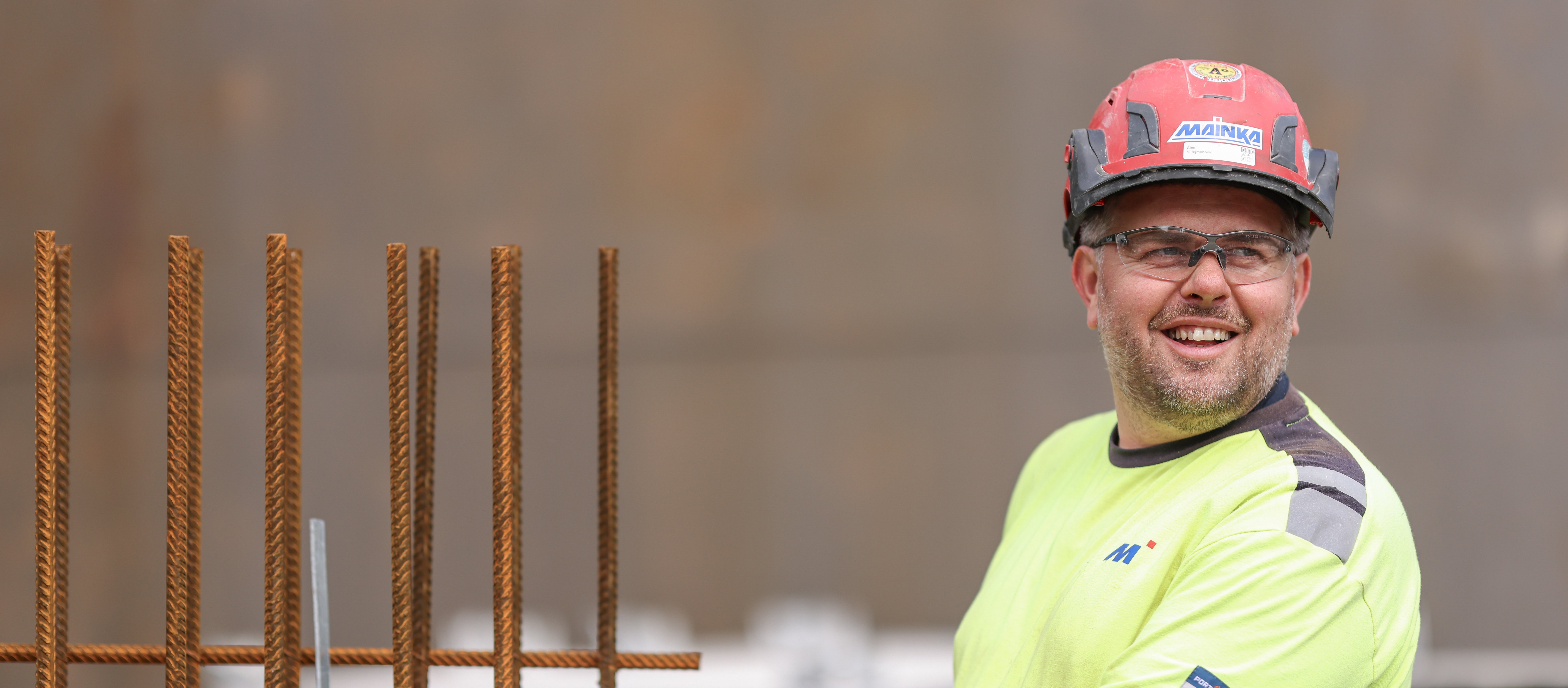 Mainka-Mitarbeiterin in Schutzausrüstung auf einer Industriebaustelle.